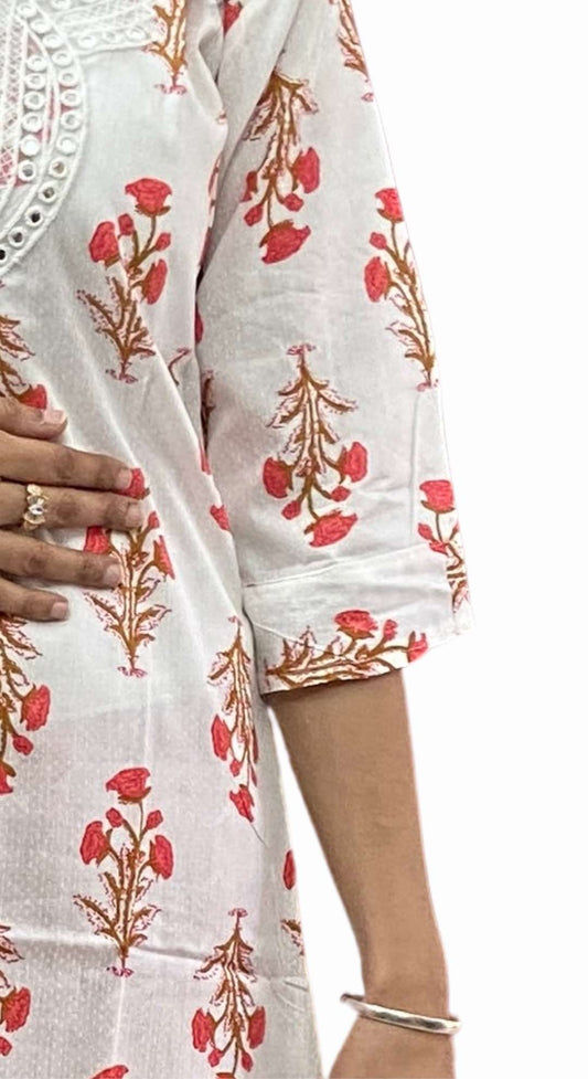White fabric with red floral patterns held by a hand on a white background