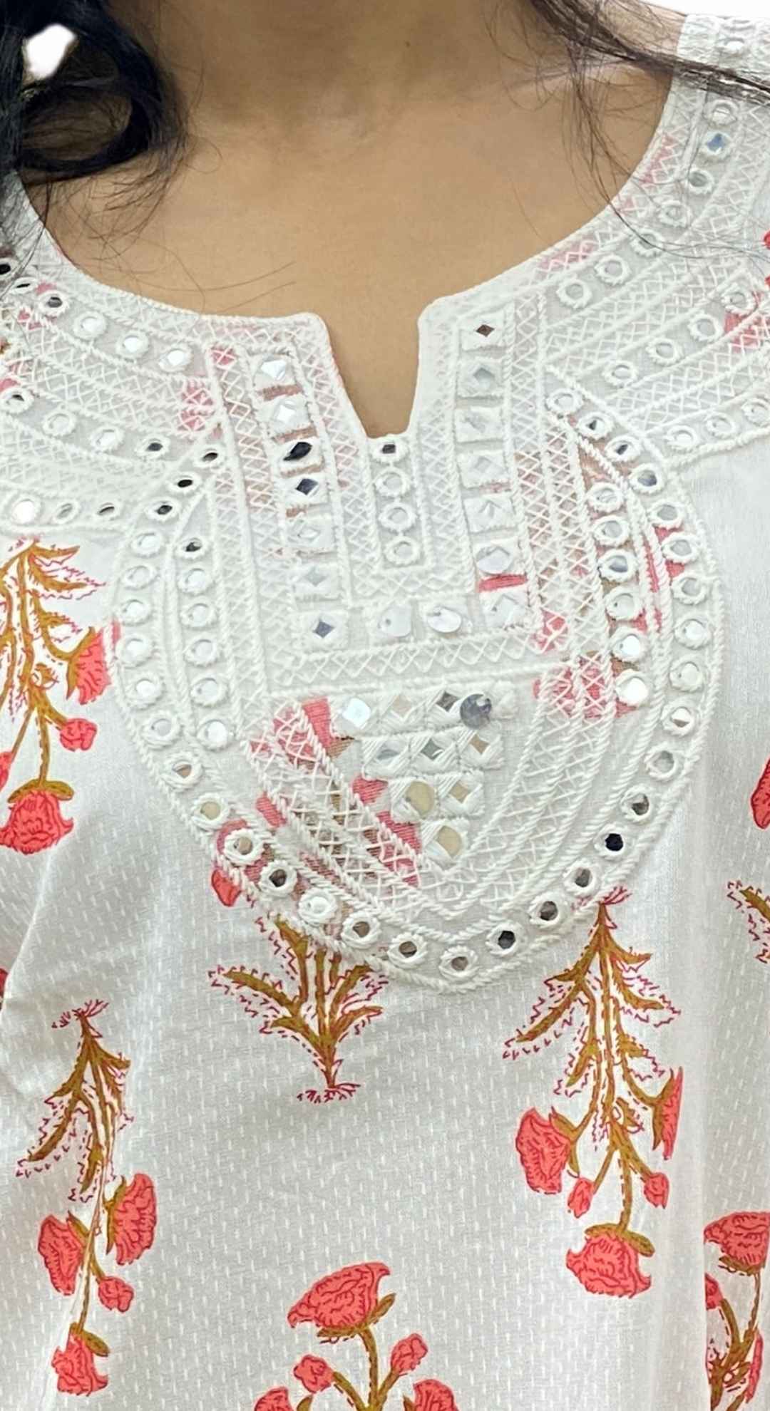 Close-up of a white embroidered garment with floral patterns